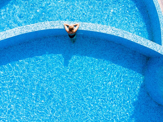 Aerial drone view of woman in pool in hotel