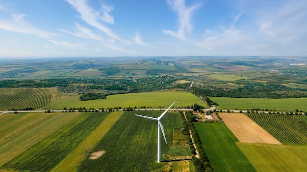 Aerial drone view of working wind turbine in Moldova Wide fields around it villag