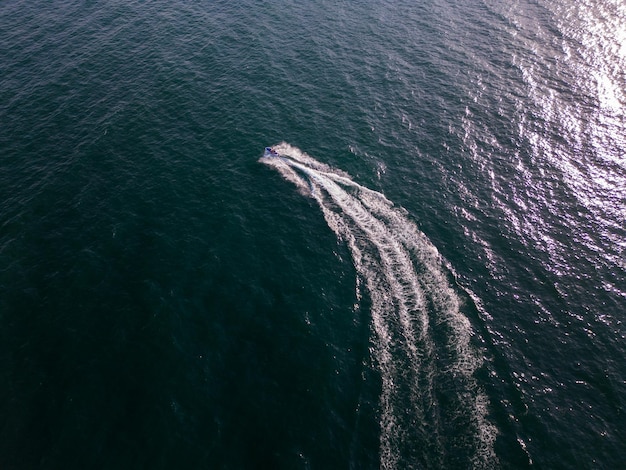Aerial dynamic view of the water scooter or personal watercraft or ski jet racing through the sea waves