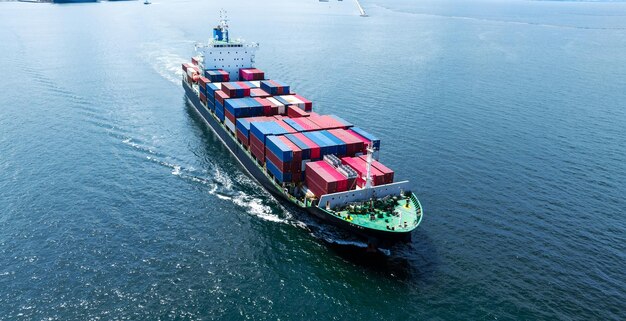 Aerial front of cargo ship carrying container and running near international custom depot sea port concept smart logistic service forwarder mast