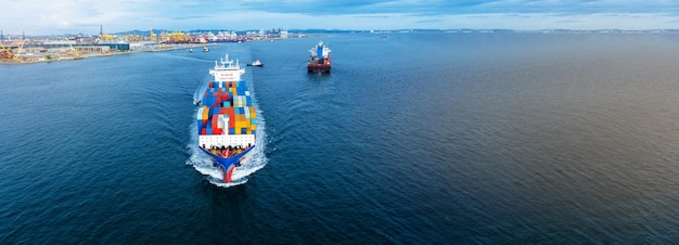 コンテナを運び、貨物ヤード港からカスタムオーシャンコンセプトテクノロジー輸送通関通関ブロバルトレーダーおよびロジスティクスへの輸出品のために走っている貨物船の正面図の空中