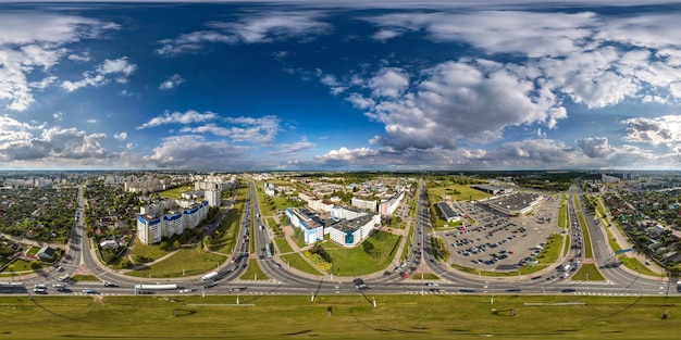 Aerial full seamless spherical hdri 360 panorama view above road junction with traffic in city overlooking of residential area of highrise buildings in equirectangular projection