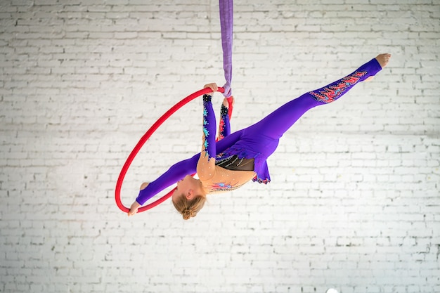 Aerial gymnastics on the circle, a little girl doing exercises