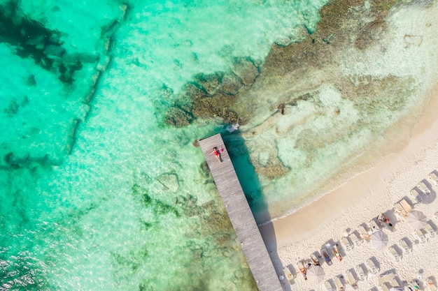 Aerial high top view of woman laying on wooden pier at sunny summer day in cancun mexico top view
