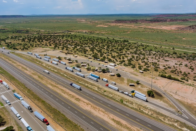 Aerial horizontal view of rest truck stop area near endless interstate highway in desert arizona