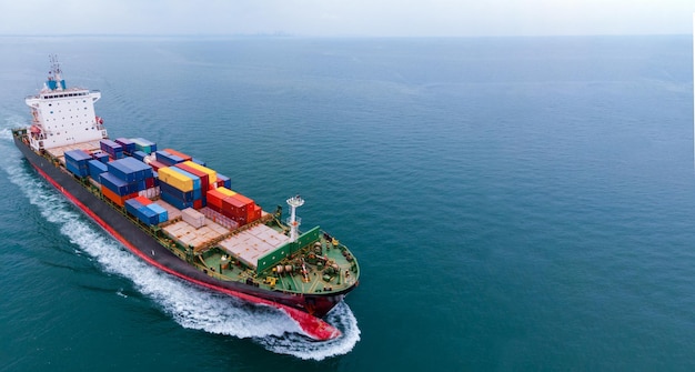 Aerial infront of cargo ship carrying container and running for export goods from cargo yard port to custom ocean concept freight shipping by ship