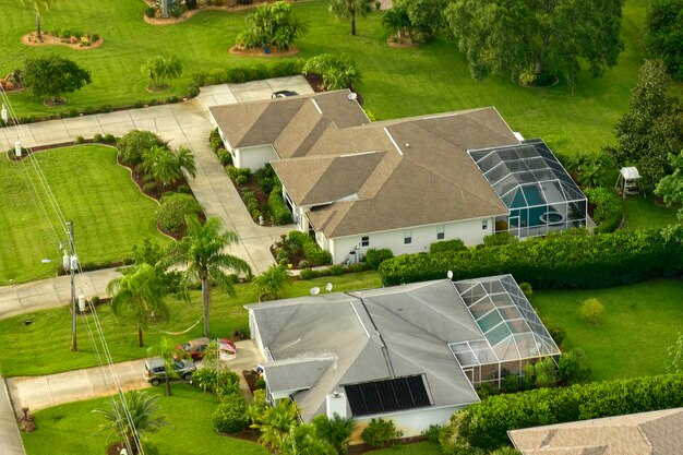 Aerial landscape view of suburban private houses between green palm trees in Florida quiet rural area