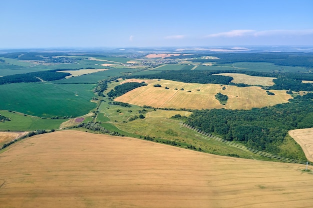 Aerial landscape view of yellow cultivated agricultural field with ripe wheat on bright summer day