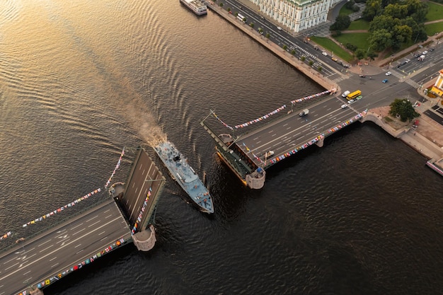 隆起した宮殿跳ね橋の上面図の黒い水の色の下で軍艦の空中風景が通過します...