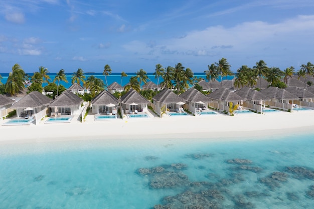 Aerial Maldives beach Beautiful palm trees luxury bungalows amazing sea Exotic travel vacation
