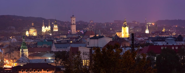 Aerial night panoramic view of churches city hall and houses roofs in historical old city of Lviv Ukraine