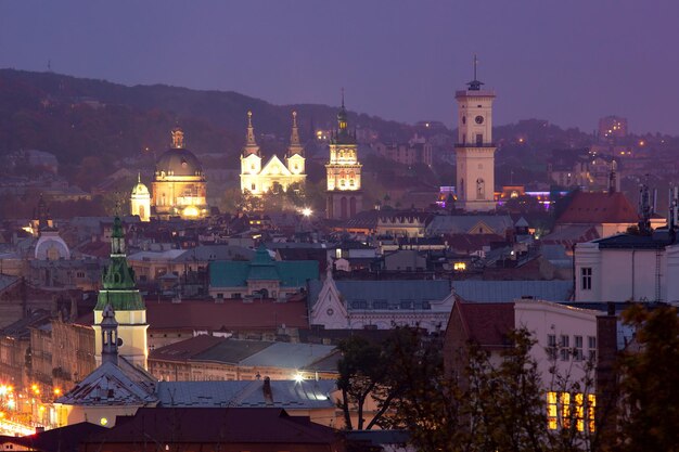 Aerial night panoramic view of churches city hall and houses roofs in historical old city of Lviv Ukraine