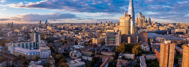 Aerial panorama of the london city financial district with many\
iconic skyscrapers near river thames at sunset.