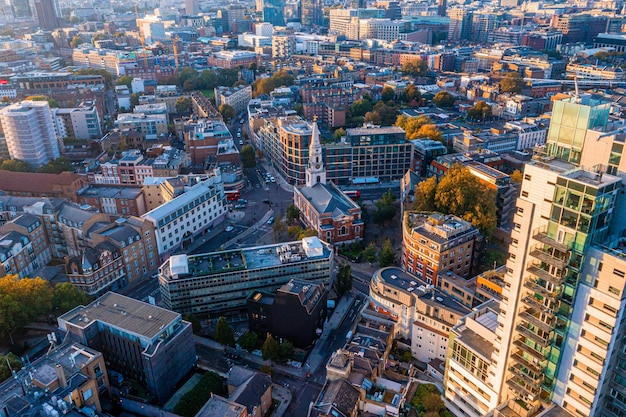 Aerial panorama of the london city financial district with many\
iconic skyscrapers near river thames at sunset.