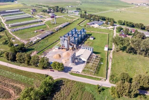 aerial panoramic view on agroindustrial complex with silos and grain drying line for drying cleaning and storage of cereal crops