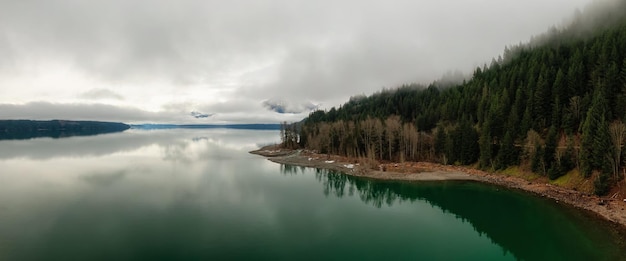 Aerial Panoramic View of Canadian Mountain Landscape covered in fog over Harrison Lake