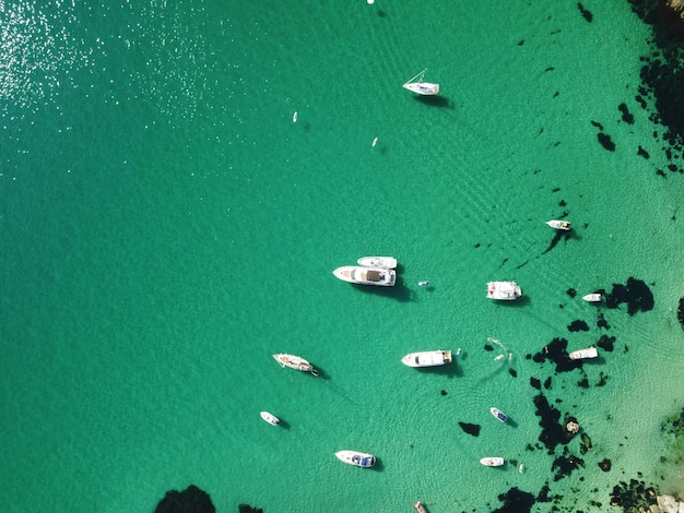 Aerial panoramic view of seascape with crystal clear azure sea and rocky shores yachts in a