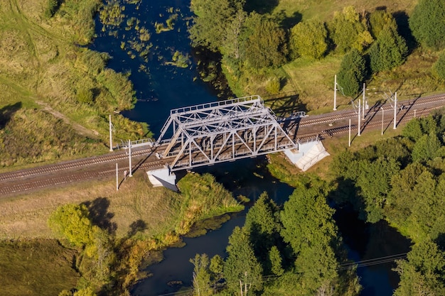 Aerial panoramic view on steel frame construction of huge train railway bridge across river