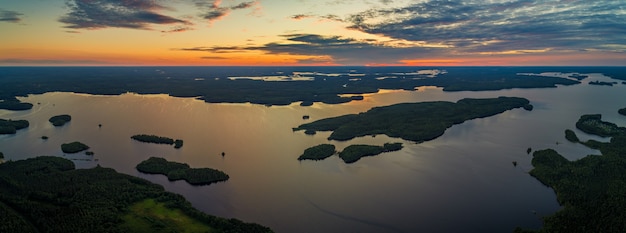 Aerial panoramic view of Suoyarvi lake at sunset surrounded by forests of Karelia, Russia