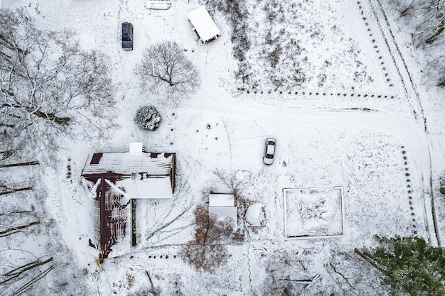 納屋の家と雪の砂利道のある村の空中パノラマ冬景色