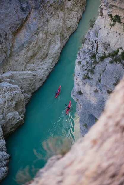 Photo aerial photo of a kayak in a river between mountains
