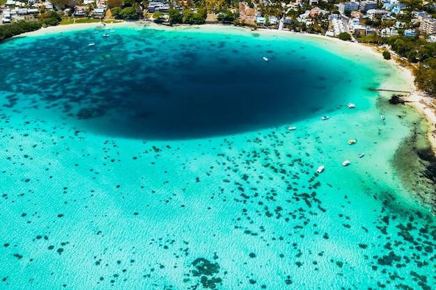 Aerial picture of the east coast of Mauritius Island. Beautiful lagoon of Mauritius Island shot from above. Boat sailing in turquoise lagoon.