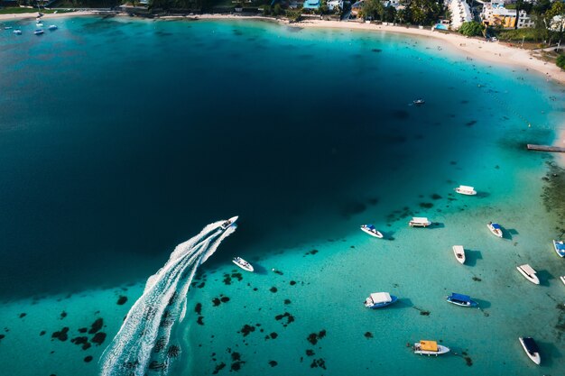 Aerial picture of the east coast of Mauritius Island. Beautiful lagoon of Mauritius Island shot from above. Boat sailing in turquoise lagoon.