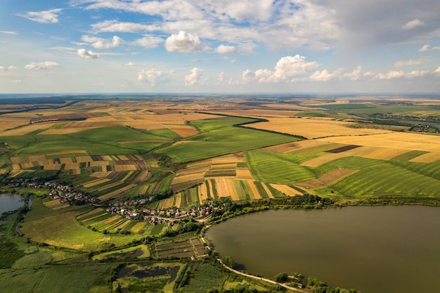 Aerial rural landscape with yellow patched agriculture fields and blue sky with white clouds.