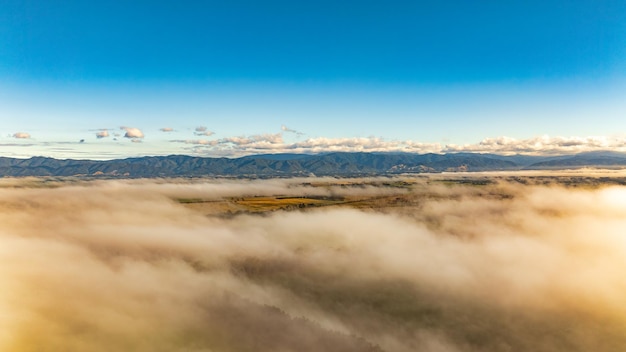 写真 谷の低い雲と雲の上にある山脈の空中景色
