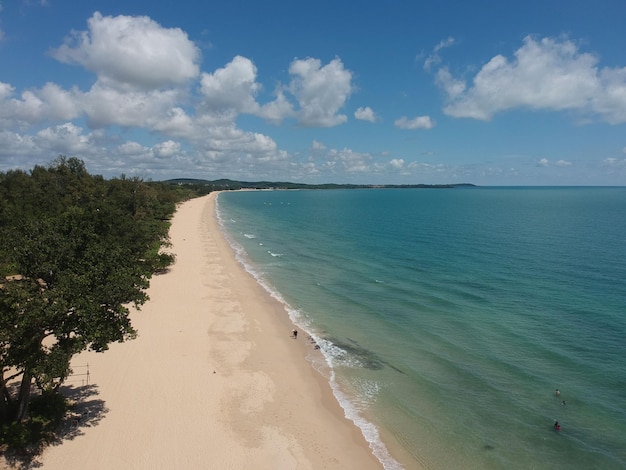 Aerial shot of the sandy Desaru beach in Malaysia alongside the clam blue sea on a sunny day