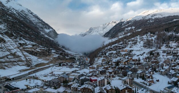 Aerial shot of zermatt switzerland displays chalets and hotels with snow roofs