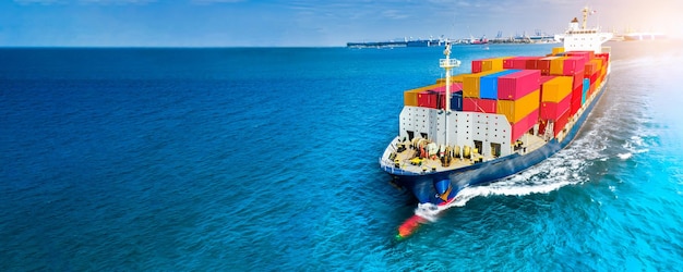 Aerial side view of cargo ship carrying container and running on blue sea for export goods from cargo yard port to custom ocean concept technology transportation customs clearance