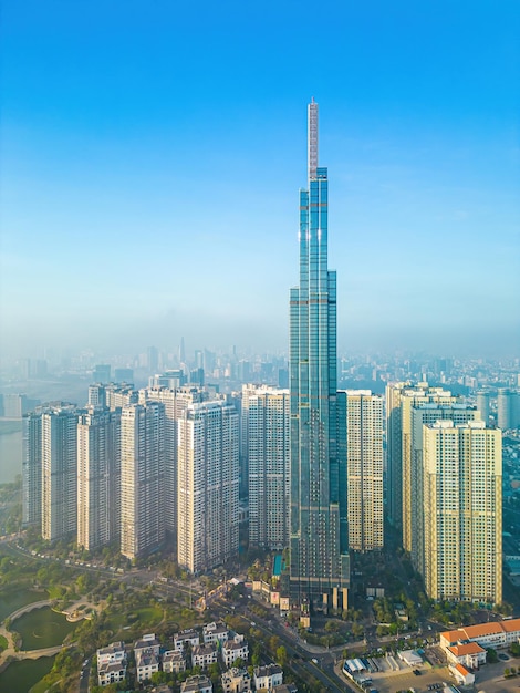 랜드마크 81(Landmark 81)의 공중 일출 전망은 도시 주변에 작은 안개가 낀 아름다운 아침에 사이공 강 도시 경관을 따라 개발 건물이 있는 초고층 마천루와 사이공 다리입니다.