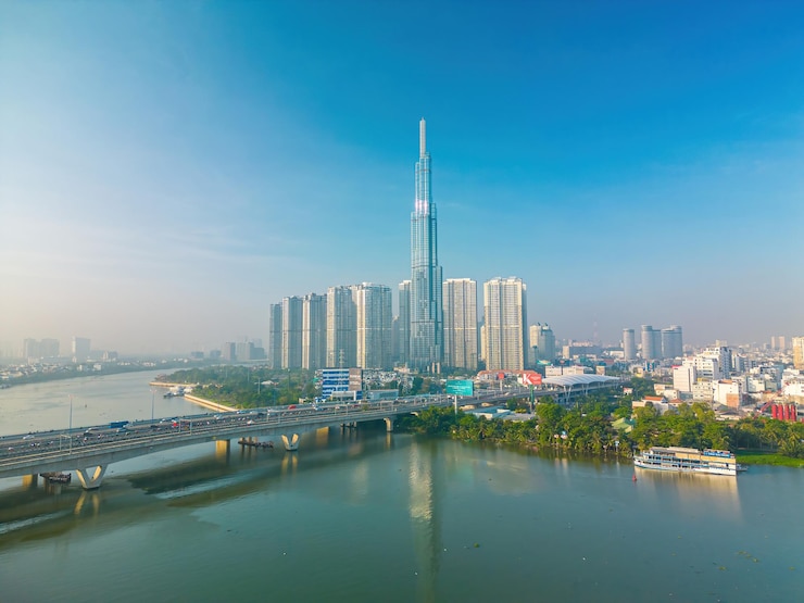 Photo aerial sunrise view at landmark 81 it is a super tall skyscraper and saigon bridge with development buildings along saigon river cityscape in the beautiful morning with small fog around city