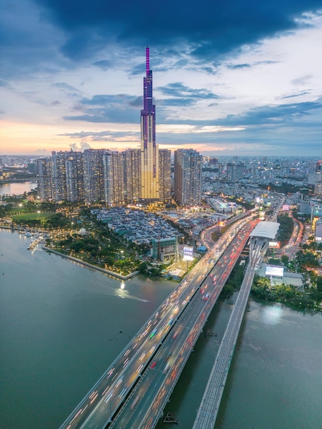 Aerial sunset view at landmark 81 it is a super tall skyscraper\
and saigon bridge with development buildings along saigon river\
light smooth down saigon skyline