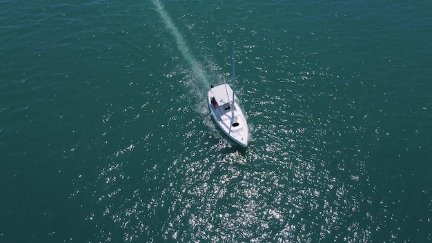 Aerial top down view of speed motor boat on open sea at summer day