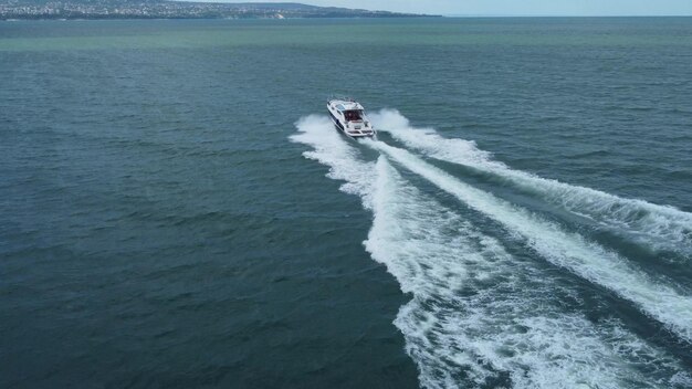 Aerial top down view of speed motor boat on open sea at summer day