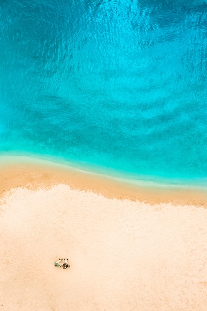 Aerial Top Drone view of a people couple on the Sand beach. Vacation sea Background. Azure Beach River water and People.