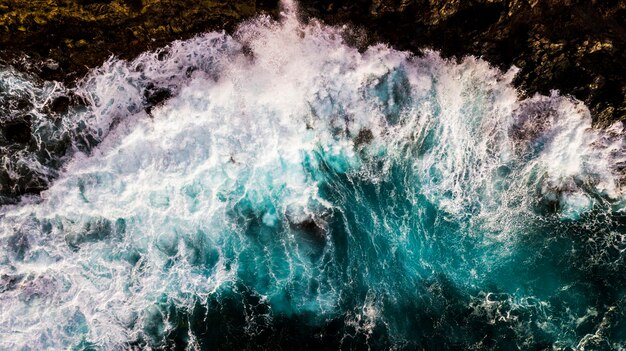 Aerial top vertical view of big waves at the beach - power of the ocean and dangerous nature