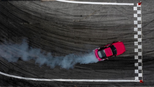 Foto aerial top view auto drijvende diffusie drift race auto met veel rook van brandende banden op snelheid