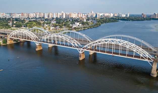 Aerial top view of automobile and railroad Darnitsky bridge across Dnieper river