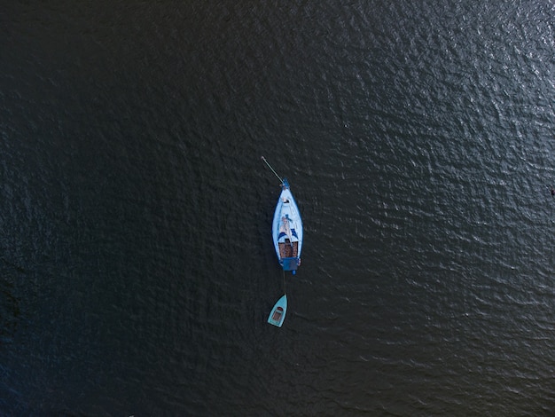 Aerial top view of a boat sailing in the lake