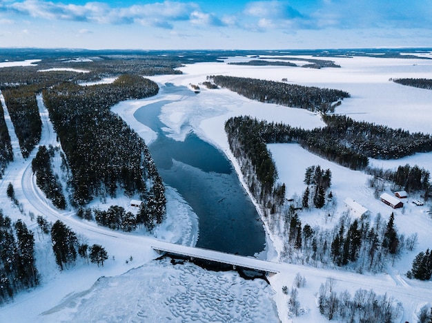 눈 겨울 핀란드 라플란드에서 얼어붙은 강 위의 다리 도로의 공중 평면도