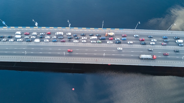 Aerial top view of the bridge with road automobile traffic of many cars