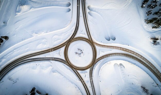 冬の国道交差点の空中写真 雪の森の道路移動と輸送コンセプト