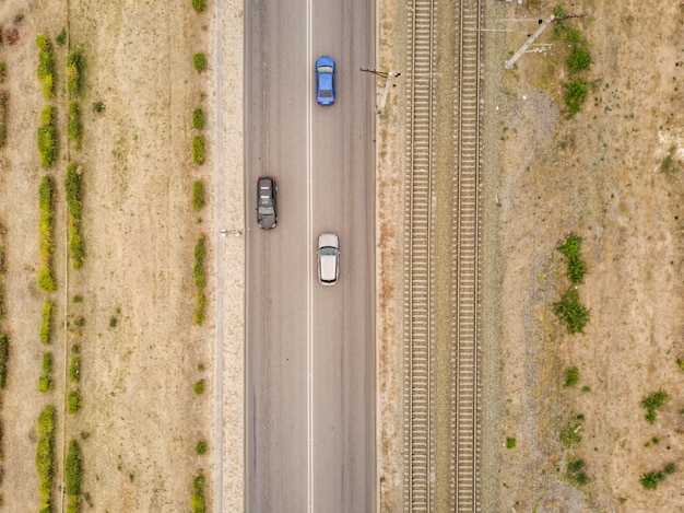 Aerial top view of countryside isolated road with railway tracks  f