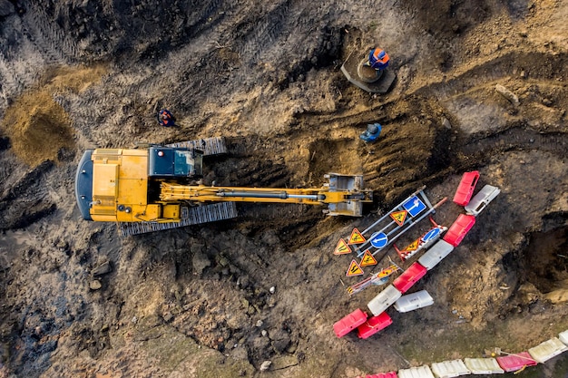 Aerial top view on crawler excavator digging ground for overhaul road Construction machinery performs energy intensive heavy work on project