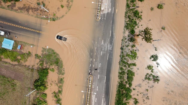 Aerial top view of Flooded the village and Country road with car, View from above shot by drone