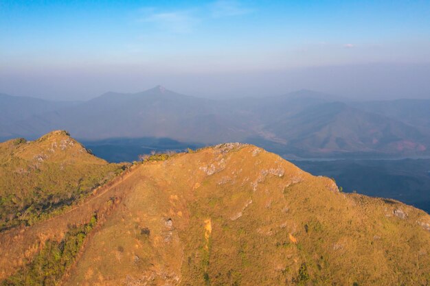 Aerial top view of forest trees and green mountain hills with fog mist and clouds nature landscape background thailand