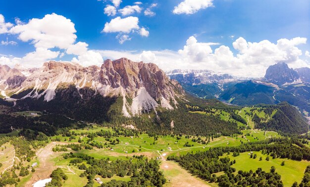 Foto vista aerea dall'alto dal drone all'altopiano del col raiser nella soleggiata giornata estiva scenario dell'aspro monte sella con valle verde sul villaggio collinare erboso di santa cristina di val gardena bolzano seceda italia